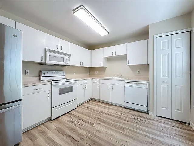 front view of house with a yard and palm trees