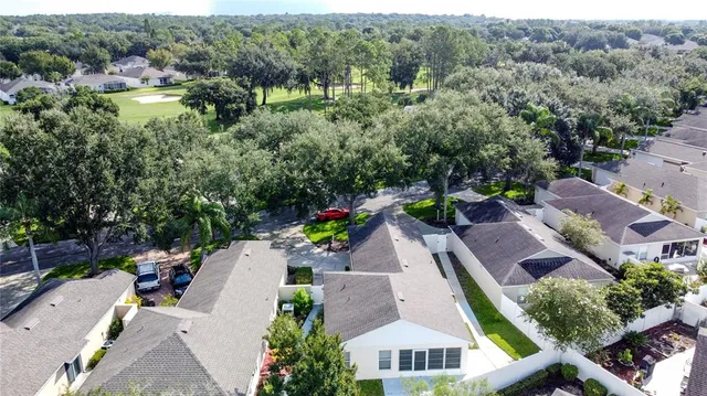 a view of a house with backyard and a parking area