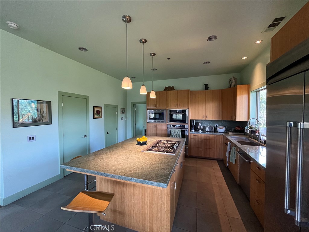 240 Rich Gulch Road Oroville, CA 95965 - Photo 20 of 49 a large kitchen with kitchen island a stove a sink a refrigerator and a dining table