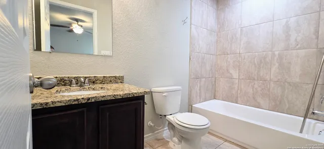 a bathroom with a granite countertop sink toilet and shower