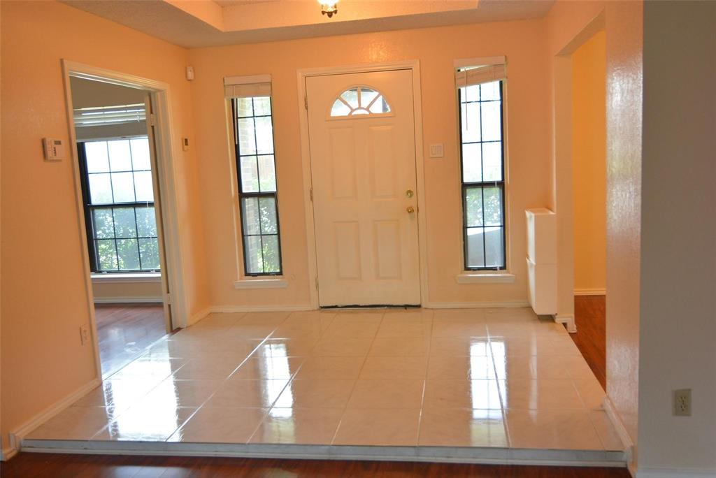 210 Apollo Road Garland, TX 75040 - Photo 5 of 23 Entryway featuring a tray ceiling, tiled flooring, sidelight windows, and a panel door with an arched lite