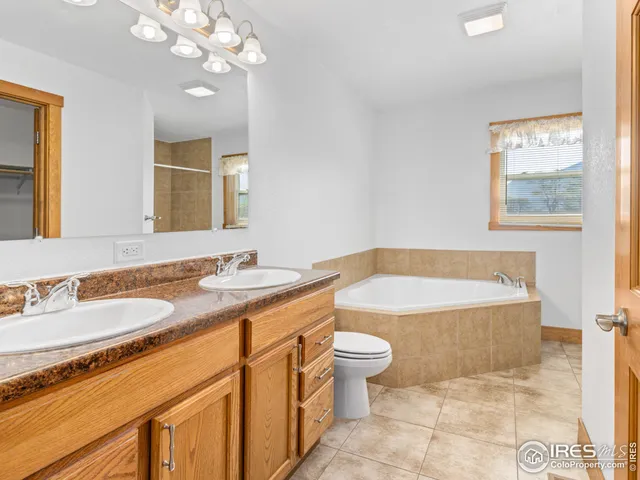 a bathroom with a granite countertop bathtub a sink and a mirror