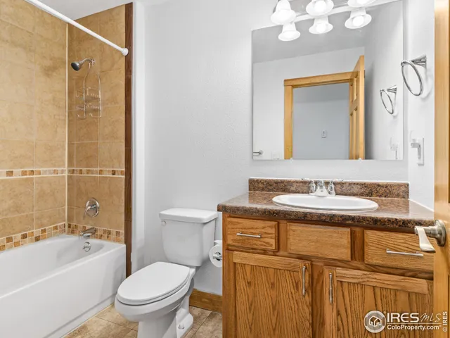 a bathroom with a granite countertop toilet sink and mirror
