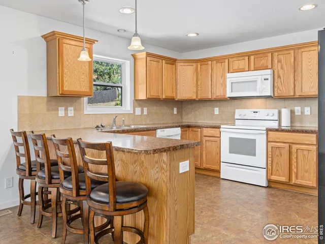 a kitchen with a table chairs sink and cabinets