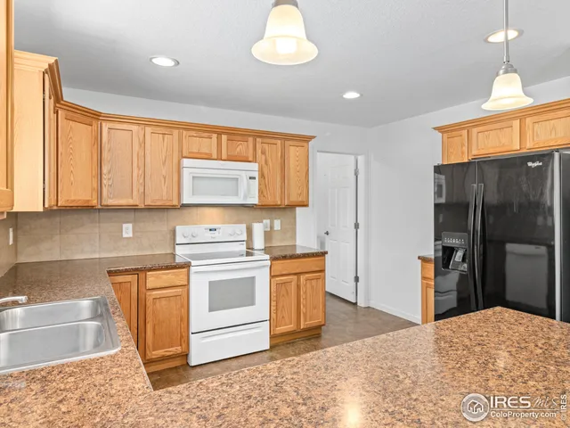 a kitchen with stainless steel appliances granite countertop a stove a sink and a refrigerator