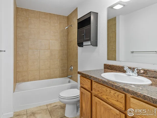 a bathroom with a granite countertop sink a toilet and bathtub