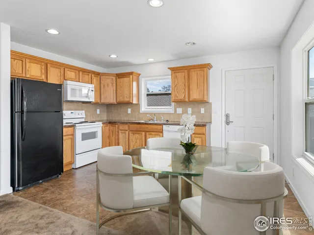 a kitchen with stainless steel appliances granite countertop a refrigerator and a stove top oven