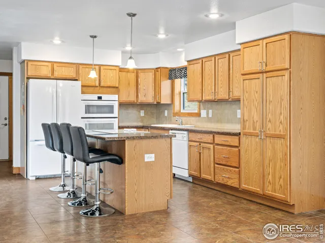 a kitchen with kitchen island granite countertop a sink cabinets and wooden floor