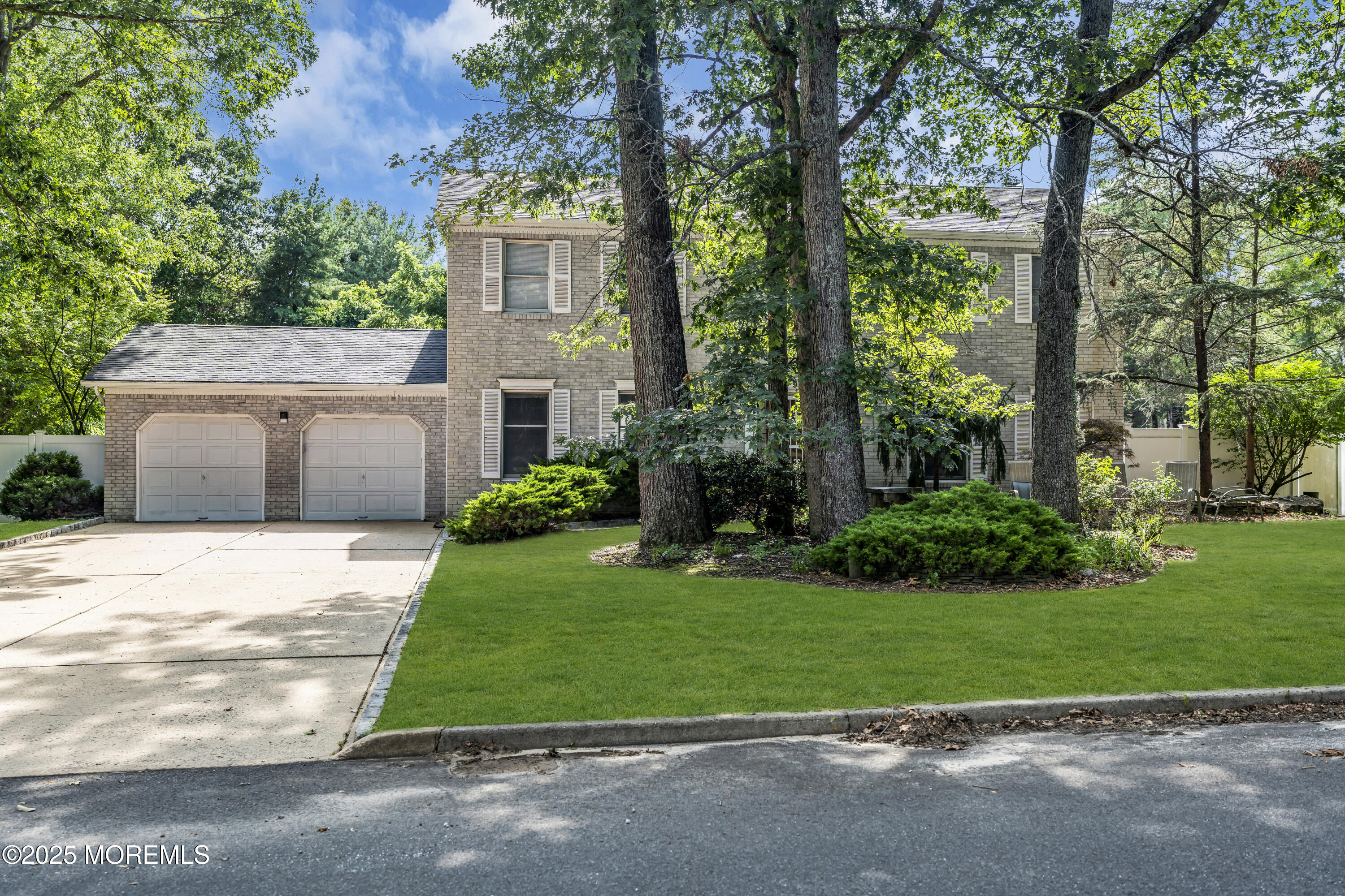 a front view of a house with a yard and trees