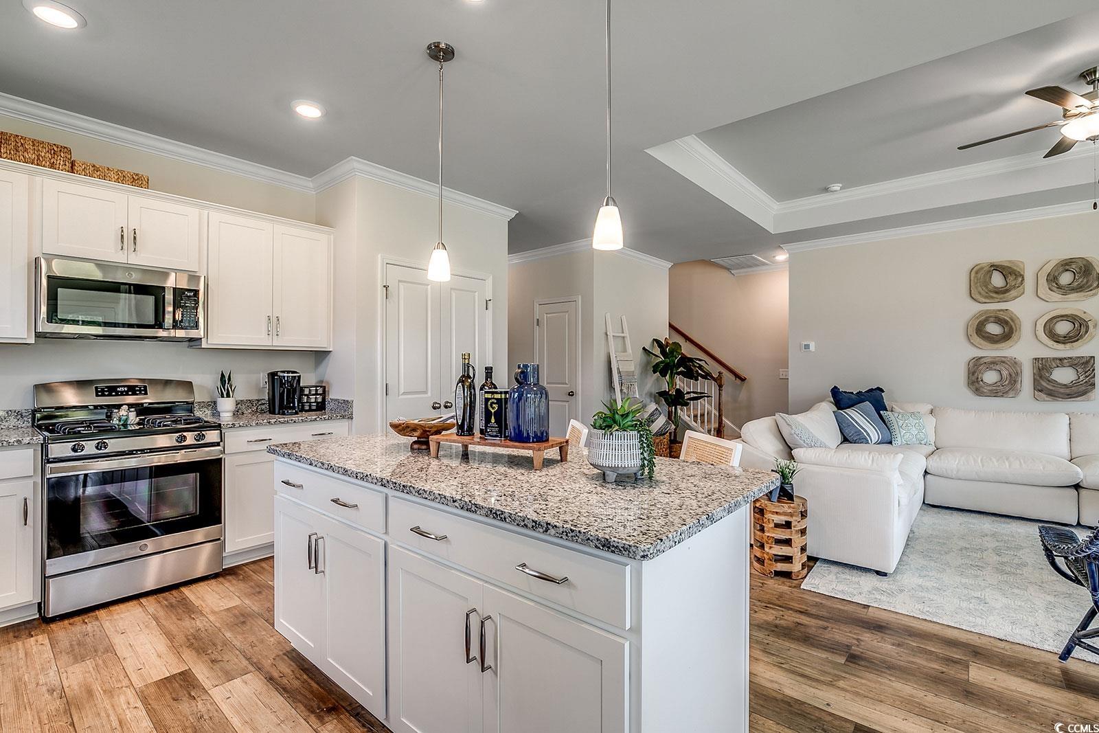 240 Wagner Circle Conway, SC 29526 - Photo 26 of 26 Kitchen with appliances with stainless steel finishes, light wood-type flooring, ornamental molding, open floor plan, and a kitchen island