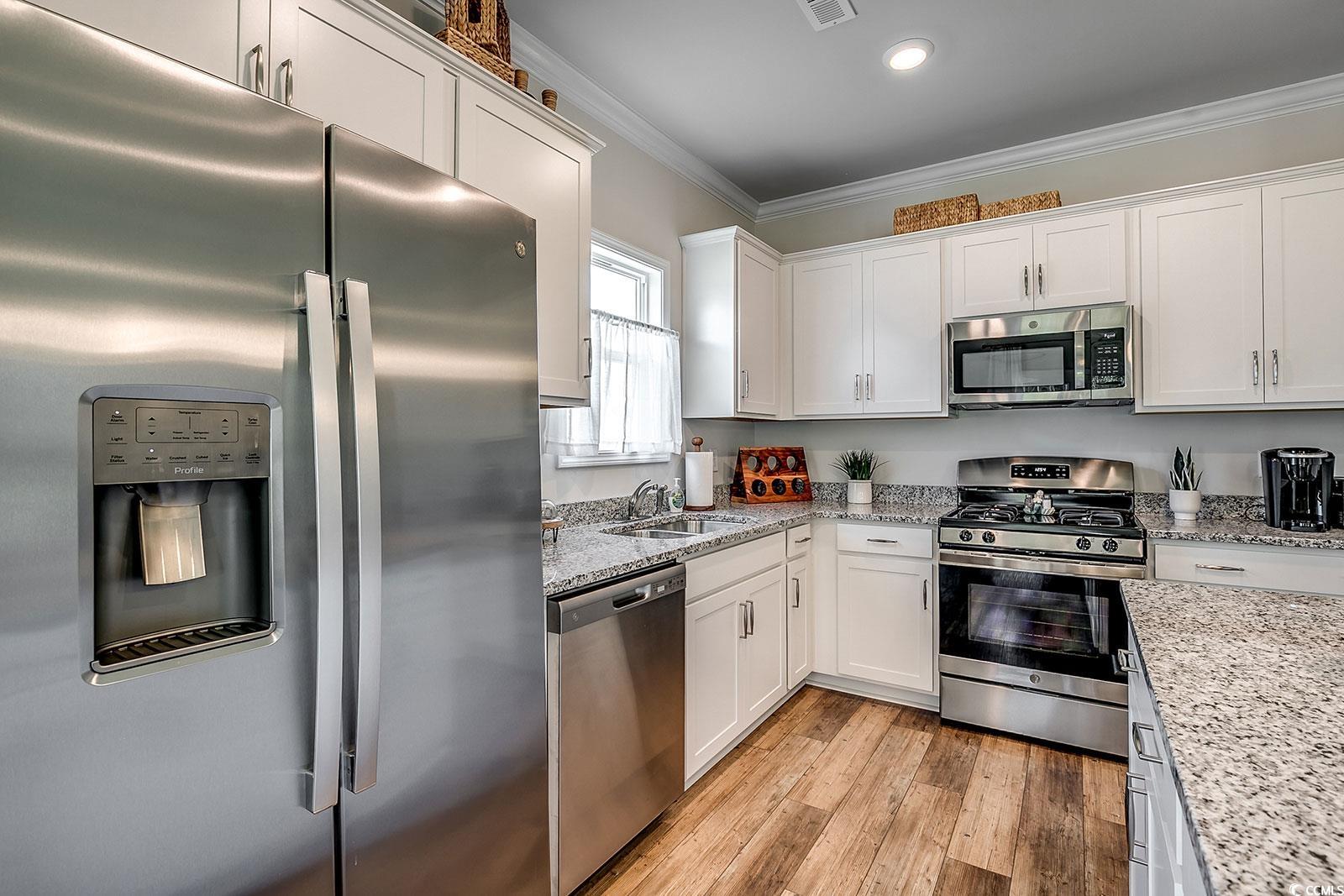 240 Wagner Circle Conway, SC 29526 - Photo 7 of 26 Kitchen with appliances with stainless steel finishes, a sink, ornamental molding, white cabinetry, and light wood finished floors