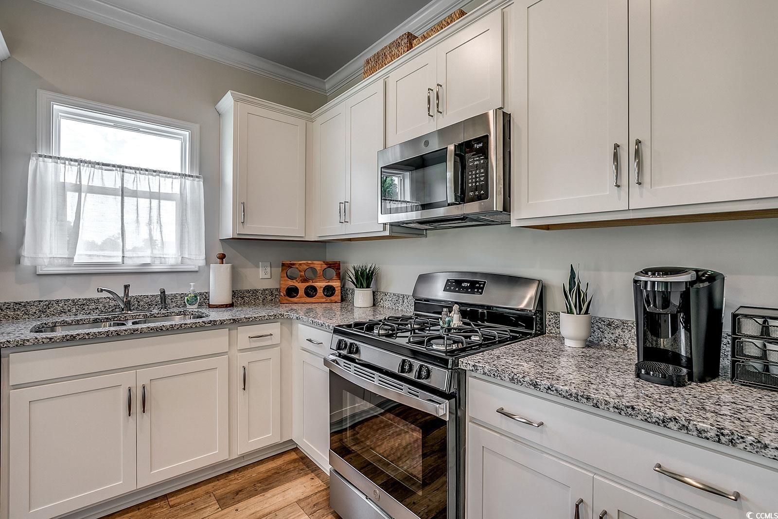 240 Wagner Circle Conway, SC 29526 - Photo 8 of 26 Kitchen with appliances with stainless steel finishes, a sink, crown molding, white cabinetry, and light stone counters