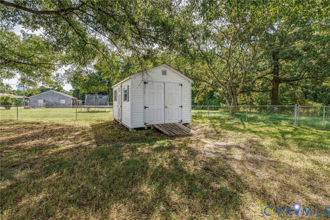 10215 River Road Petersburg, VA 23803 - Photo 26 of 31 White storage shed with double doors, wood ramp, a