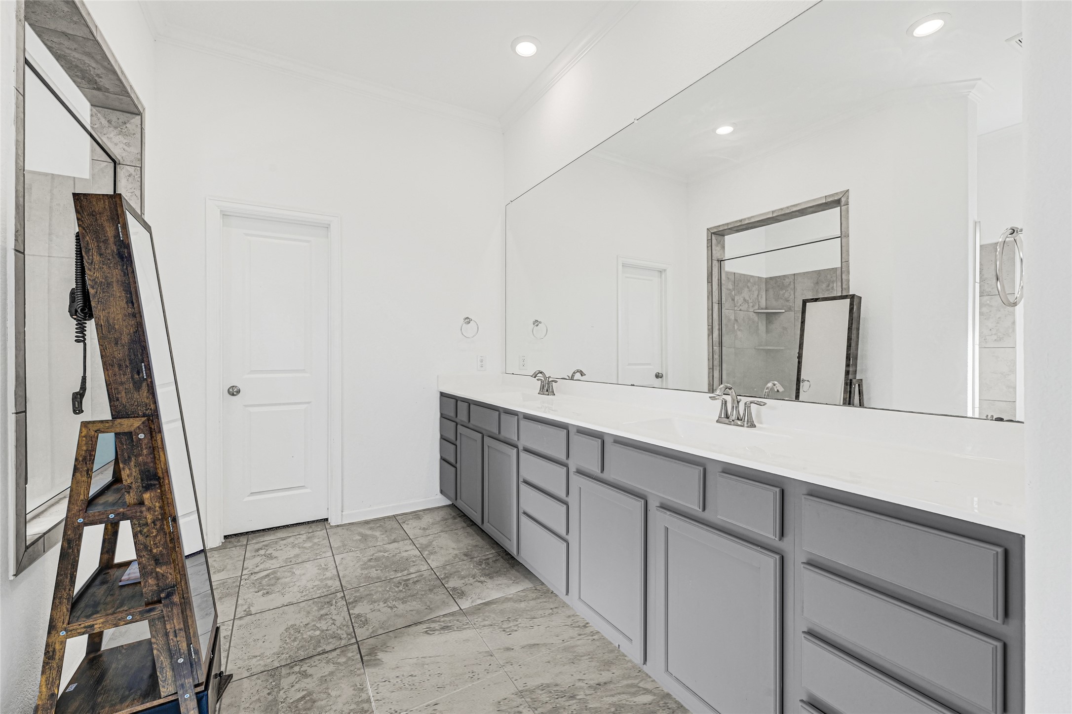 4307 Annandale Lane Rosharon, TX 77583 - Photo 11 of 31 This spacious primary bathroom features a large double sink with vanity with ample storage and a sleek, expansive mirror. The modern design is complemented by neutral tile flooring and a separate shower area, creating a clean and functional space.