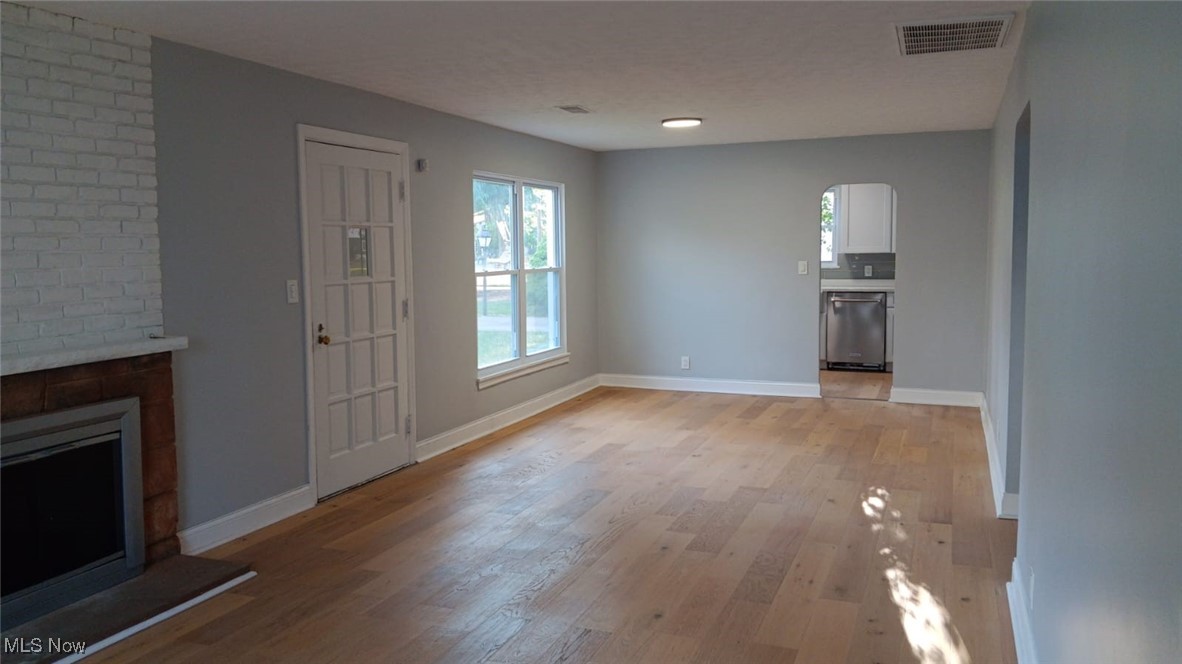 3999 Lancaster Road South Euclid, OH 44121 - Photo 12 of 17 Unfurnished living room featuring a brick fireplace and light wood-type flooring
