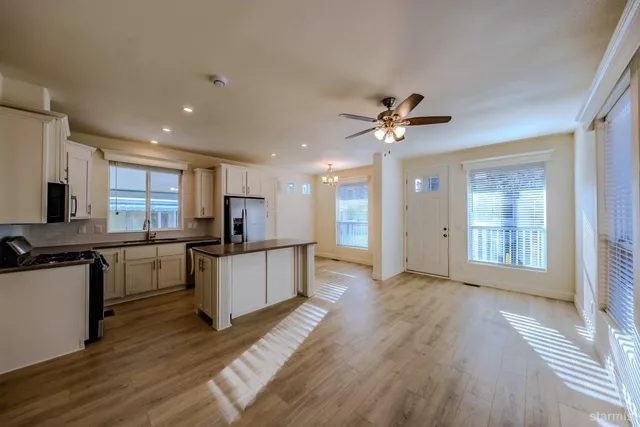 a large kitchen with granite countertop a stove top oven a sink a counter space and cabinets