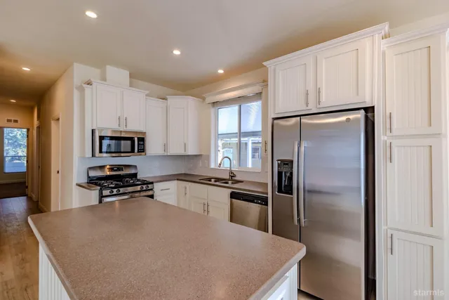 a kitchen with stainless steel appliances granite countertop a refrigerator stove microwave and sink