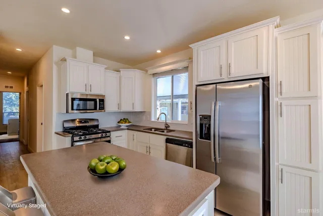 a kitchen with stainless steel appliances granite countertop a refrigerator stove microwave and sink