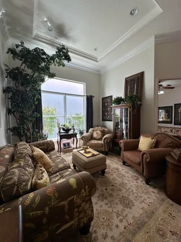 a living room with stainless steel appliances furniture a flat screen tv and a kitchen view