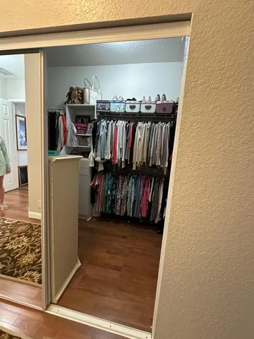 a view of a hallway with wooden floor and stairs