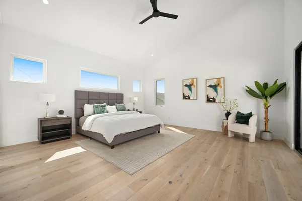 a bedroom with a large bed and a chandelier