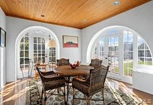 a dining room with furniture a chandelier and wooden floor