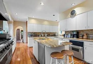 a kitchen with a stove a sink a counter top space and cabinets