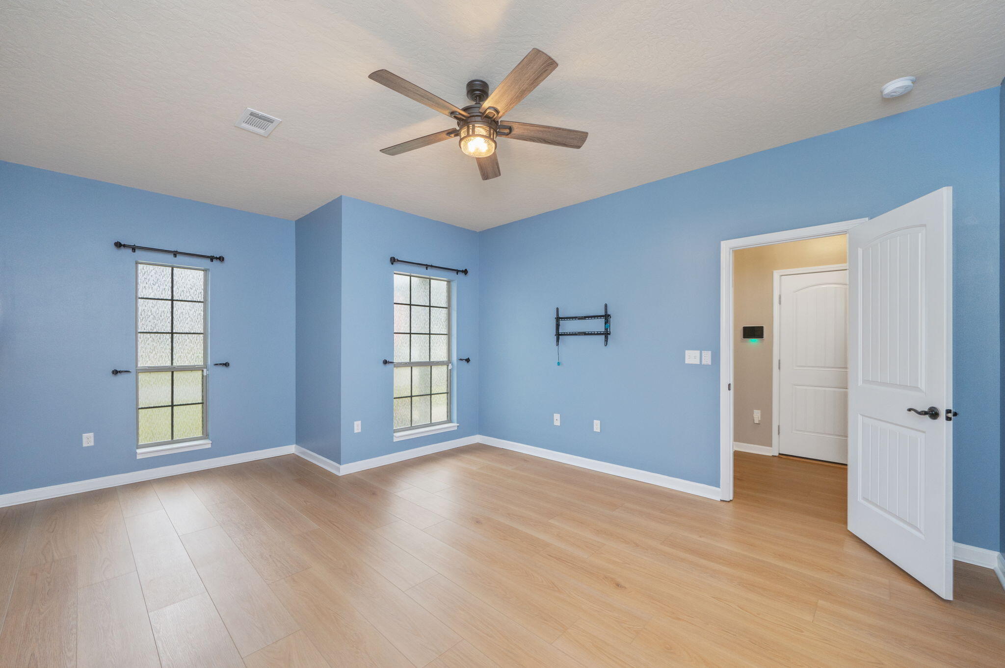 5275 Moore Loop Crestview, FL 32536 - Photo 14 of 32 a view of an empty room with window and wooden floor