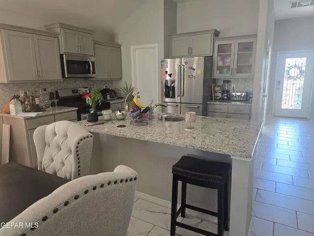 a kitchen with stainless steel appliances granite countertop a stove a sink and a microwave