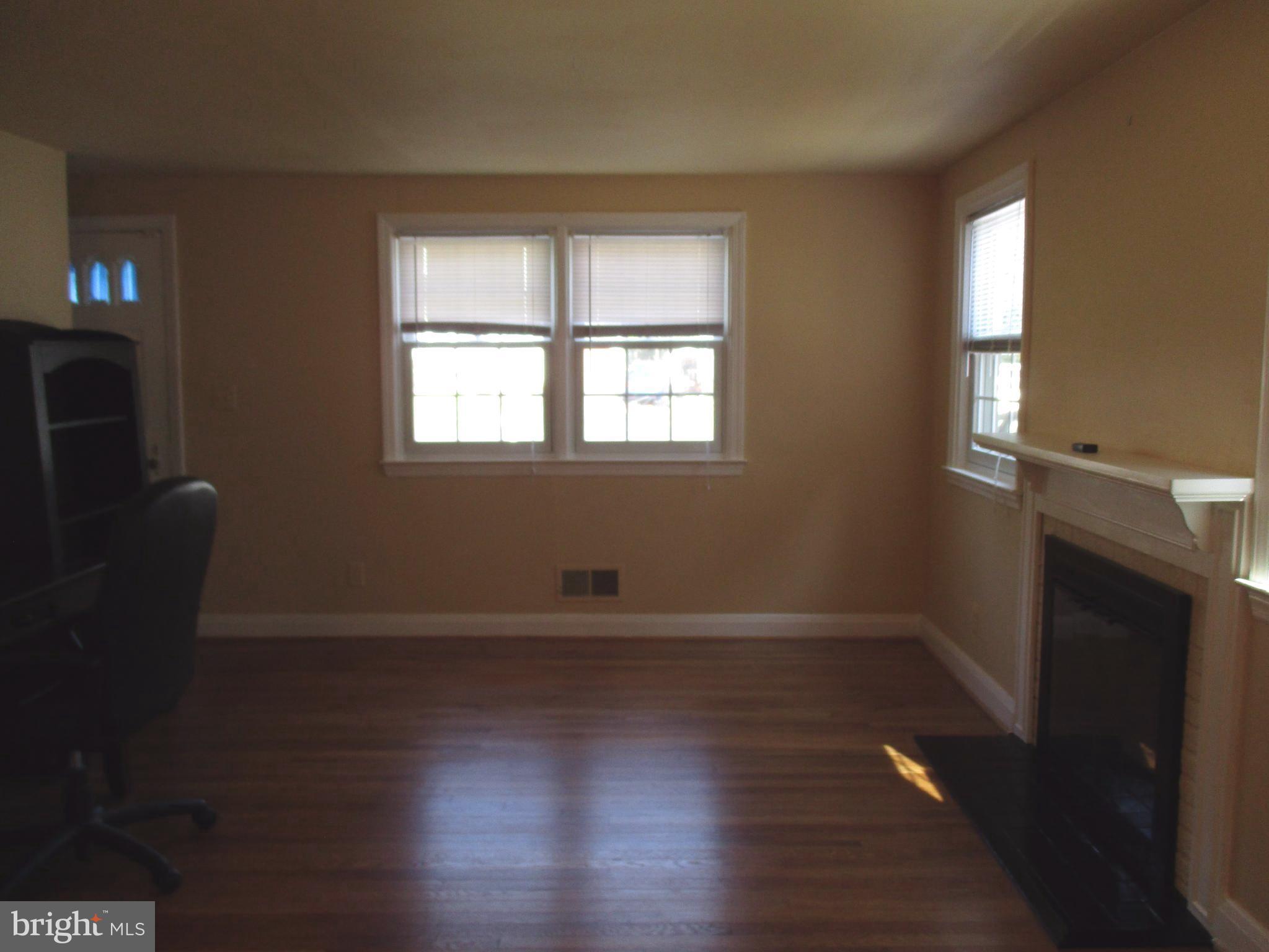 3507 Rolling Rd. Baltimore, MD 21244 - Photo 5 of 8 an empty room with wooden floor and windows