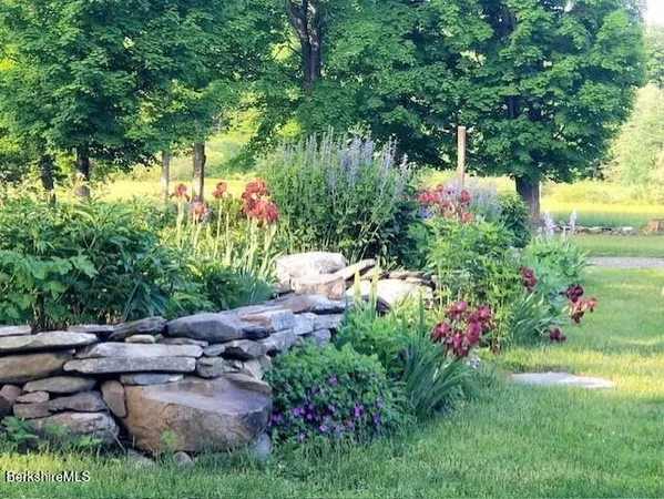a front view of a house with a yard and fountain