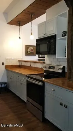 a kitchen with stainless steel appliances granite countertop a sink a stove and microwave