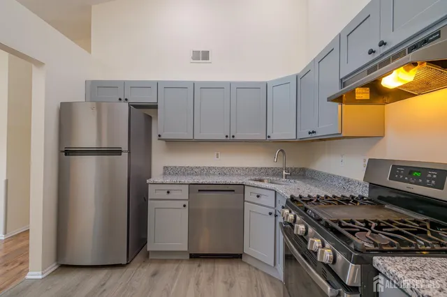 a kitchen with a stove a refrigerator and a sink