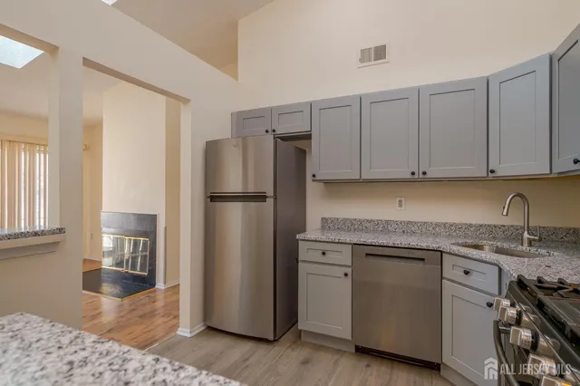 a kitchen with stainless steel appliances granite countertop a refrigerator sink and cabinets