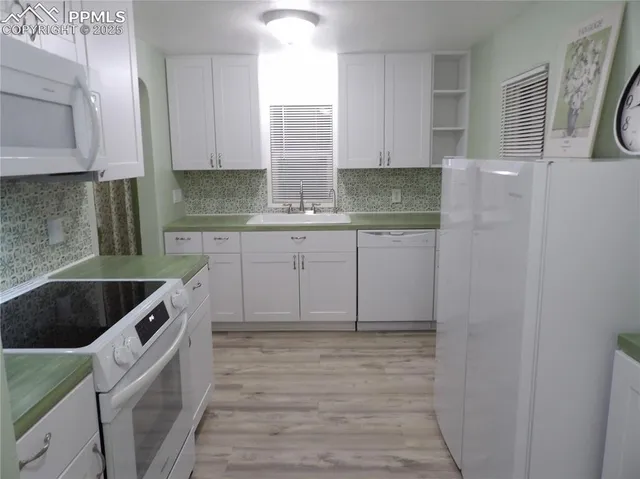 a kitchen with granite countertop a sink and cabinets