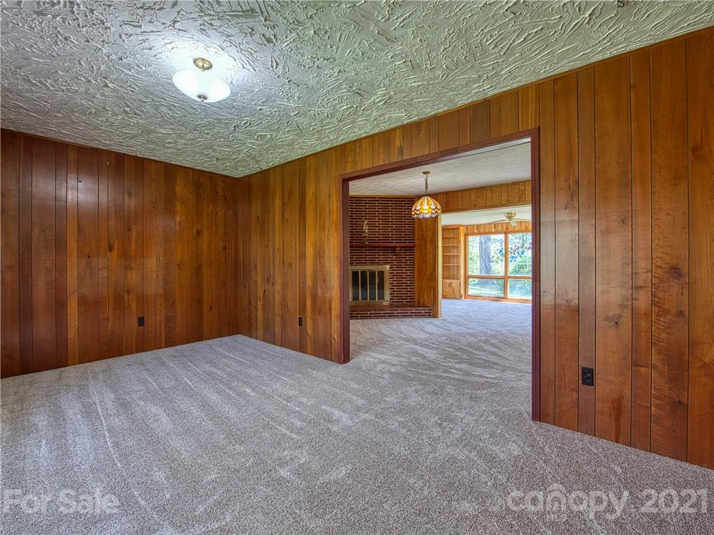 720 Iron Duff Road Waynesville, NC 28785 - Photo 11 of 37 a view of an empty room with a fireplace and a window
