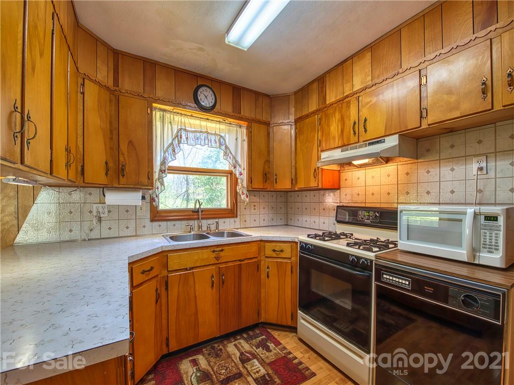 720 Iron Duff Road Waynesville, NC 28785 - Photo 17 of 37 a kitchen with stainless steel appliances granite countertop a stove a sink and a microwave