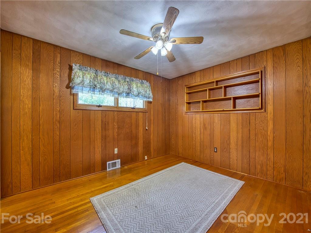 720 Iron Duff Road Waynesville, NC 28785 - Photo 30 of 37 a bedroom with a bed and a chandelier