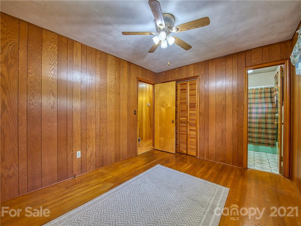 720 Iron Duff Road Waynesville, NC 28785 - Photo 31 of 37 a bedroom with a bed and a chandelier