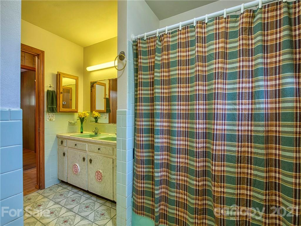 720 Iron Duff Road Waynesville, NC 28785 - Photo 32 of 37 a bathroom with a double vanity sink a mirror and shower