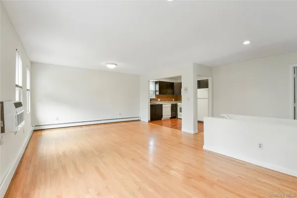 a view of a big room with wooden floor and windows