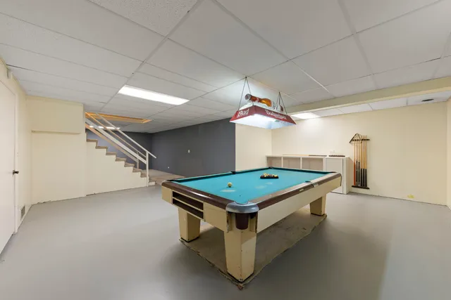 a room with pool table and windows