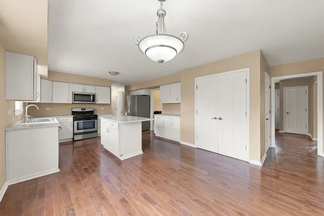 a view of kitchen with cabinets stainless steel appliances and wooden floor