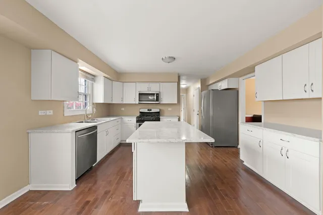 a kitchen with refrigerator cabinets and wooden floor
