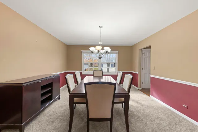 a dining room with furniture a chandelier and wooden floor