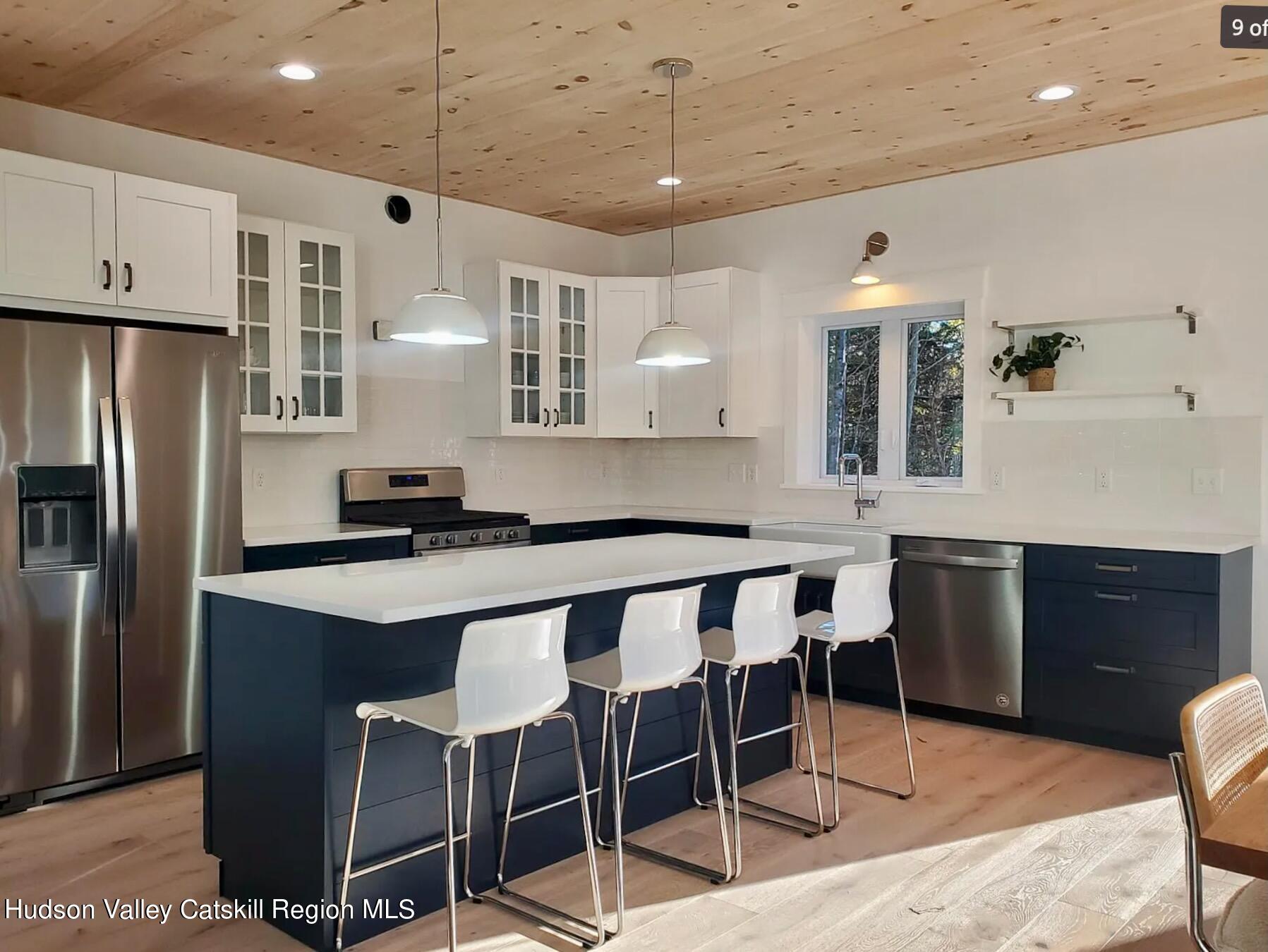 382 Beaverkill Road Olivebridge, NY 12461 - Photo 7 of 40 a kitchen with stainless steel appliances granite countertop a sink a stove a refrigerator cabinets and chairs