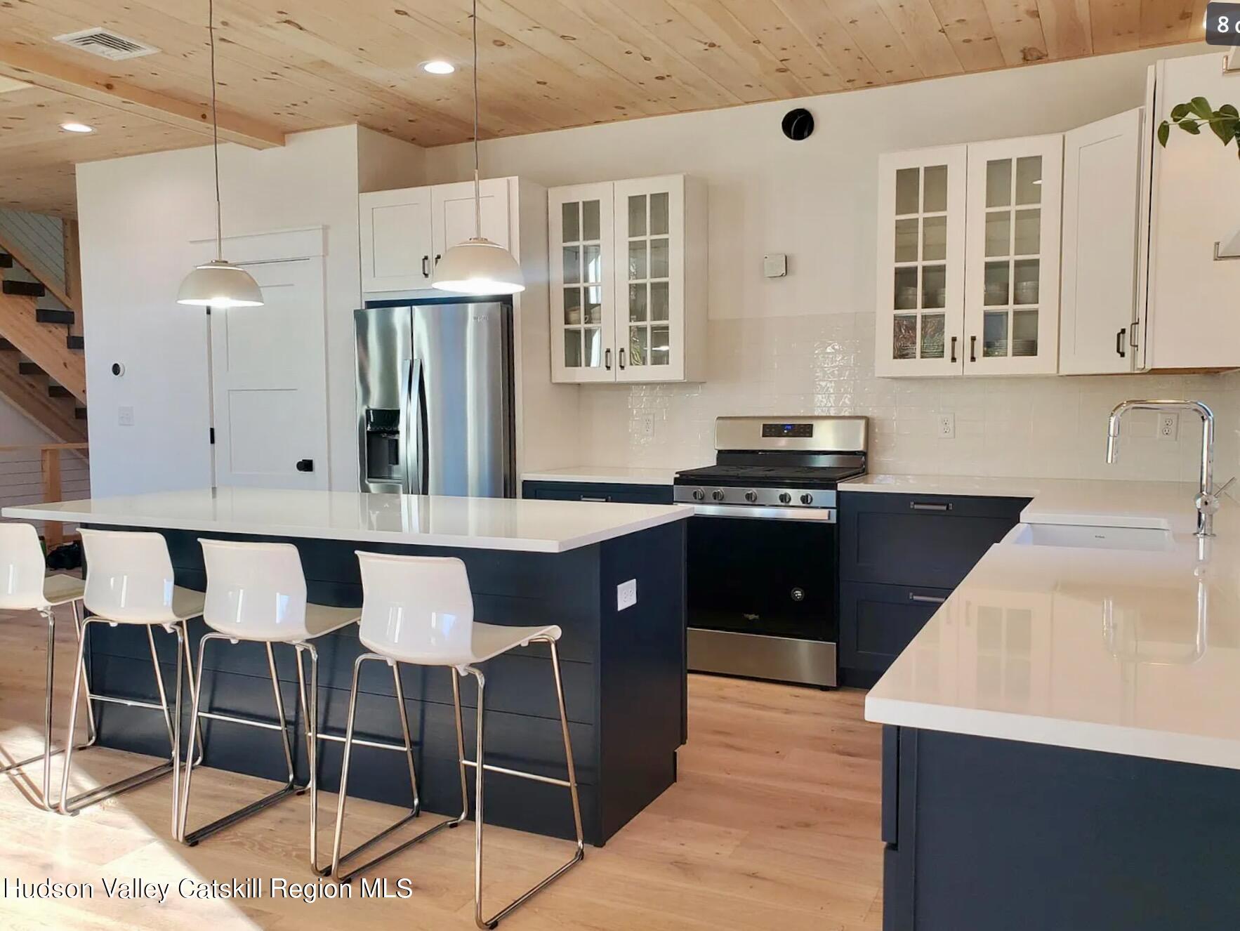 382 Beaverkill Road Olivebridge, NY 12461 - Photo 8 of 40 a kitchen with stainless steel appliances granite countertop a sink a stove a refrigerator and island with wooden floor