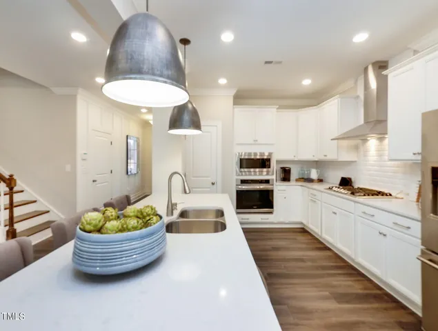 a large white kitchen with lots of white furniture and a sink