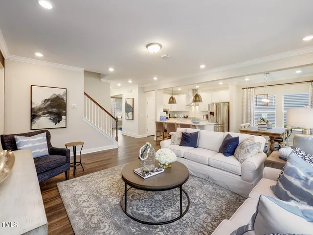 a living room with furniture and a view of kitchen