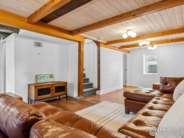 a view of a livingroom with hardwood floor and furniture